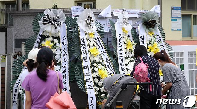 지난해 8월27일 서울 한 초등학교 교문 앞에서 학부모들이 그린스마트 미래학교 선정 반대 서명을 하고 있다. /뉴스1 © News1 김명섭 기자