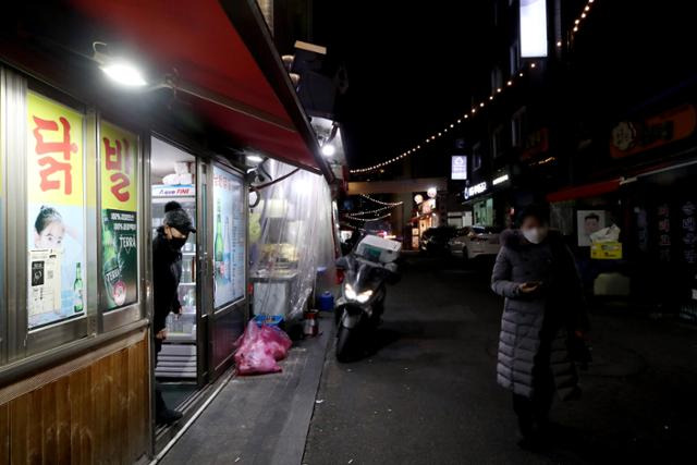 지난 6일 서울 중구 백학시장의 한 식당 소상공인이 강화된 사회적 거리두기 연장을 비판하는 점등시위를 하고 있다. 뉴시스