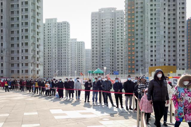 중국 수도 베이징의 관문인 톈진에서 9일 시민들이 코로나19 검사를 받기 위해 줄지어 서 있다. 톈진=EPA 연합뉴스