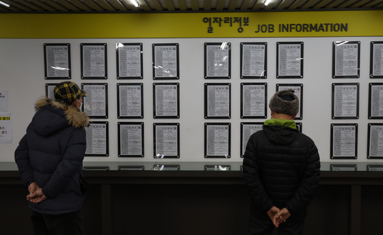 Visitors looking for job openings on a bulletin board at a job center in Seoul earlier this month. [YONHAP]