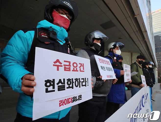 라이더유니온 관계자들이 13일 오후 서울 중구 서울지방고용노동청 앞에서 열린 플랫폼배달노동자에 대한 차별적인 사회보험 개선 촉구 기자회견에서 피켓을 들고 있다. 2022.1.13/뉴스1 © News1 김진환 기자