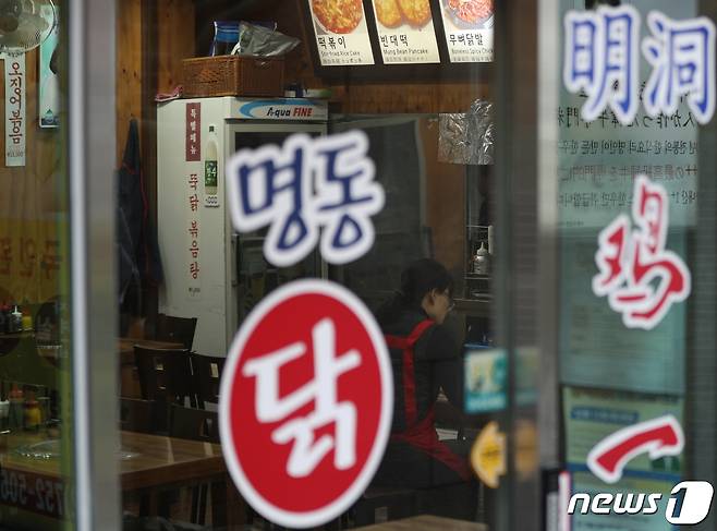 사회적 거리두기 조정안 발표를 하루 앞둔 13일 서울 중구 명동거리에서 상인이 영업 준비를 하고 있다.  2022.1.13/뉴스1 © News1 신웅수 기자