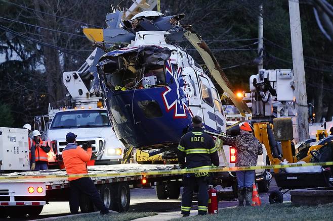 사고 헬기가 12일 현장에서 옮겨지고 있다. AP=연합뉴스