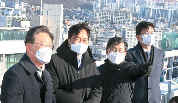 이재명 더불어민주당 대선후보(맨 왼쪽)가 13일 부동산 정책을 발표하기에 앞서 서울 노원구 한 빌딩 옥상에서 주변 노후 아파트단지를 살펴보고 있다.  [이승환 기자]