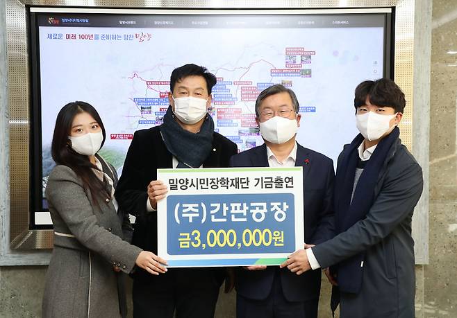 간판공장 이흥봉(왼쪽 두 접째) 대표가 박일호 시장에게 장학기금 300만원을 출연하고 있다.     *재판매 및 DB 금지