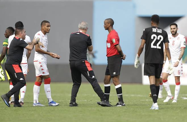 Tunisia‘s head coach Mondher Kebaier, center left, gestures to the referee Janny Sikazwe of Zambia, during the African Cup of Nations 2022 group F soccer match between Tunisia and Mali at the Limbe Omnisport Stadium in Limbe, Cameroon, Wednesday, Jan. 12, 2022. AP연합뉴스