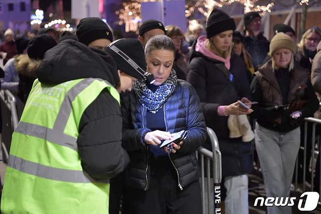 스웨덴 스톡홀름의 아비치 아레나에서 지난해 12월 열린 콘서트에 시민들이 입장을 하면서 코로나19 백신 접종 증명서를 보여주고 있다. © AFP=뉴스1 © News1 우동명 기자