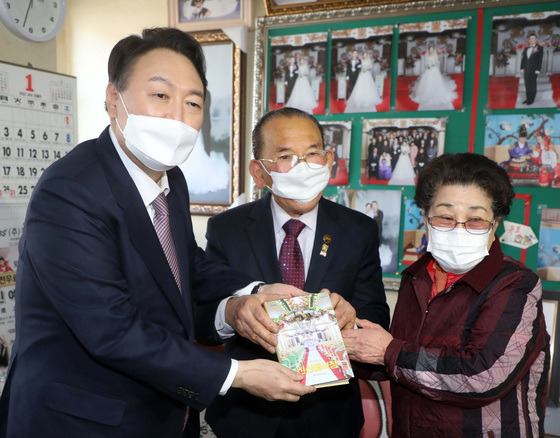 윤석열 국민의힘 대선 후보가 14일 오후 경남 창원시 마산합포구 신신예식장을 찾아 백낙삼, 최필순 부부와 만나 기념촬영을 하고 있다. 백낙삼 씨는 신신예식장을 운영하며 55년간 1만4천 쌍의 결혼식·사진 촬영을 무료로 제공해왔다. /사진=뉴스1