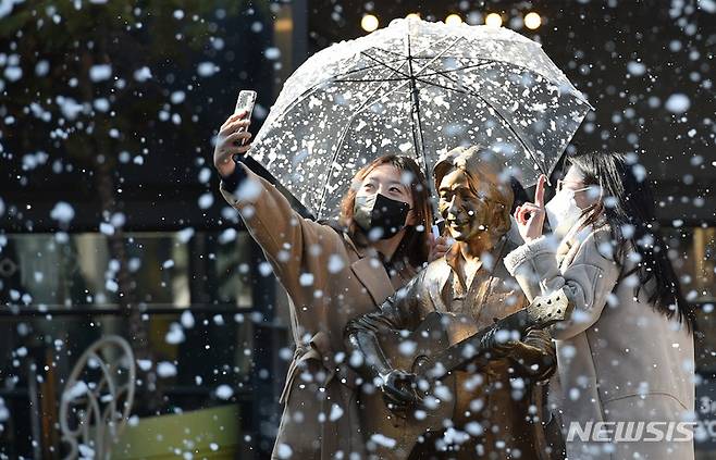 [대구=뉴시스] 이무열 기자 = 13일 오전 대구 중구 ‘김광석 다시 그리기 길’에 인공 눈이 내리고 있다. 야외 콘서트홀 출입구 옆 벽화에 서면 30초가량 인공 눈이 내리며 2월 초까지 운영된다. 2022.01.13. lmy@newsis.com