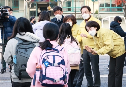 유은혜 부총리 겸 교육부 장관(오른쪽)과 조희연 서울교육감이 전면등교를 시행한 지난 달 22일 서울 용산의 한 초등학교에서 학생들을 반갑게 맞이하고 있다. 사획적 거리두기가 시행되면서 전면등교도 20일부터 철회한다.교육부 제공