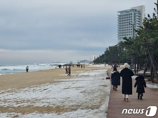 방역강화 연장 시행을 앞둔 15일 강원 강릉 경포해변에 바닷바람을 쐬기위해 나온 나들이객이 해변을 걷고 있다.2022.1.15/뉴스1 윤왕근 기자