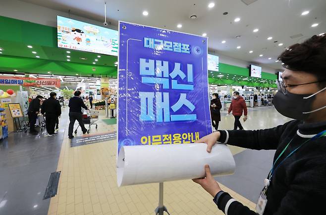 법원이 서울 마트·백화점에 대해 방역패스 효력 정지를 결정한 14일 오후 서울 서초구 양재동 농협하나로마트에서 관계자들이 방역패스 안내문을 치우고 있다./연합뉴스