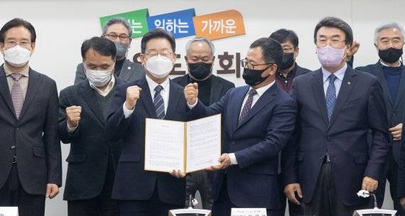 이재명 더불어민주당 대선 후보가 강원도 매타버스(매주 타는 민생버스) 민생투어 첫 날인 15일 강원 춘천시 강원도의회에서 열린 강원도 18개 시군 번영회장 간담회에서 정책 건의문을 전달받으며 기념촬영을 하고 있다. 2022.1.15/뉴스1 © News1 오대일 기자 /사진=뉴스1