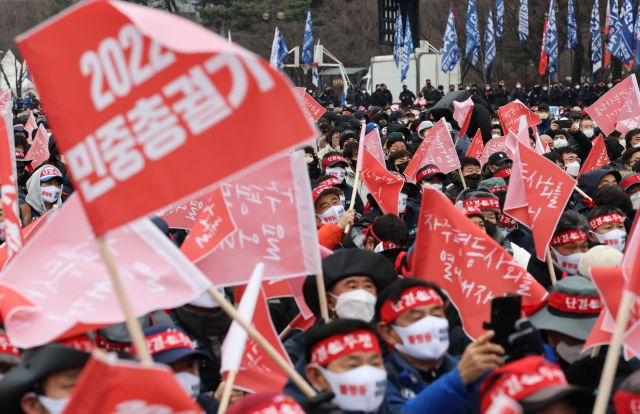 15일 서울 여의도에서 열린 '2022 민중총궐기 대회' 집회 참석자들이 깃발을 흔들며 구호를 외치고 있다. 연합뉴스