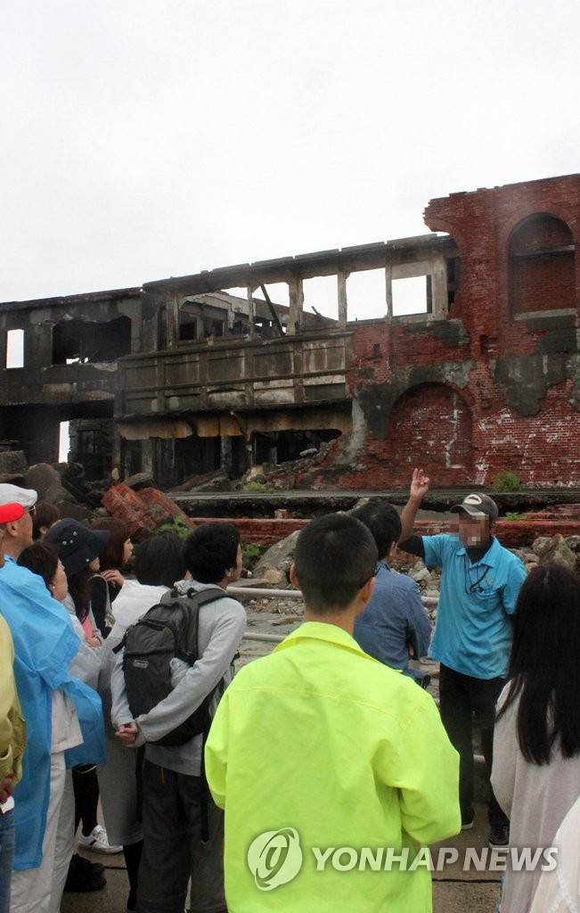 군함도에 관해 설명 듣는 관광객 (나가사키=연합뉴스) 이세원 특파원 = 2015년 6월 5일 일본 나가사키현 서쪽 바다에 있는 하시마(端島, 일명 '군함도')에서 방문자들이 군함도에 관해 현지 여행업체 직원의 설명을 듣고 있다.