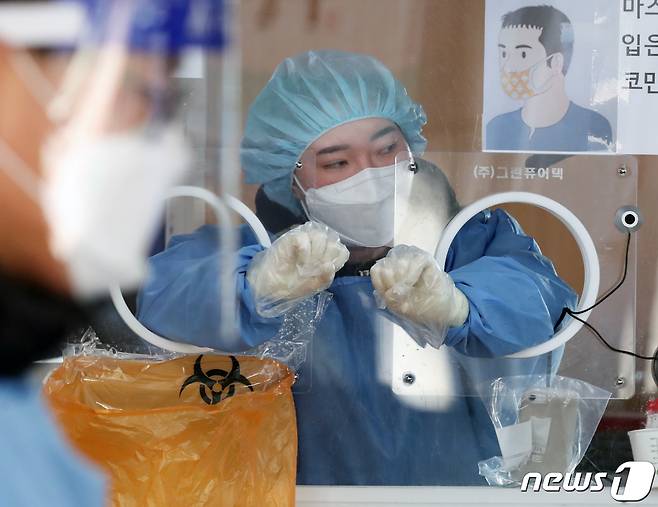 16일 오전 서울 중구 서울역 앞 신종 코로나바이러스 감염증(코로나19) 임시선별검사소에서 의료진이 검체 검사를 앞두고 손을 움직이며 풀고 있다. 중앙방역대책본부는 16일 0시 기준 코로나19 신규 확진자가 4194명이라고 밝혔다. 신규 확진자 감염 경로는 국내 발생이 3813명, 해외 유입이 381명이다. 2022.1.16/뉴스1 © News1 송원영 기자