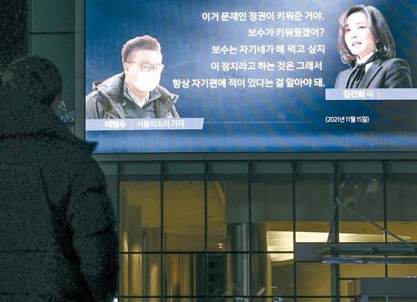 16일 저녁 윤석열 국민의힘 대선후보 부인 김건희 씨의 `7시간 전화 통화` 내용이 방송되자 한 시민이 서울 상암동 MBC 사옥 전광판을 통해 이를 지켜보고 있다. [사진 = 연합뉴스]