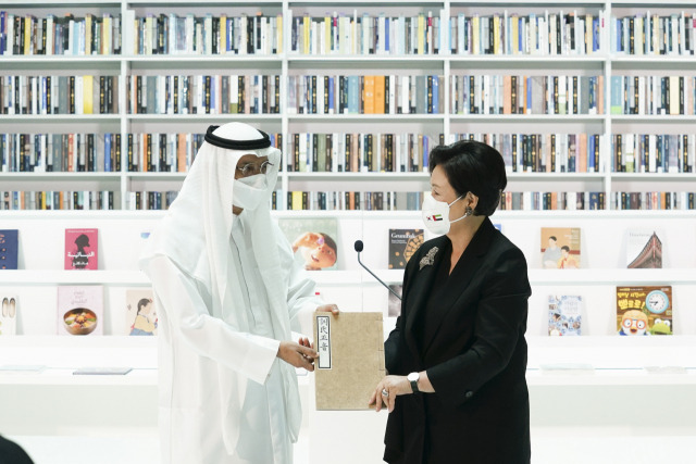 김정숙 여사가 16일(현지시간) 아랍에미리트(UAE) 두바이 모하메드빈라시드(MBR) 도서관에서 열린 한-UAE 지식문화 교류식에서 모하메드 살람 알마즈루이 MBR 도서관장에게 훈민정음 해례본 영인본을 기증하고 있다./연합뉴스