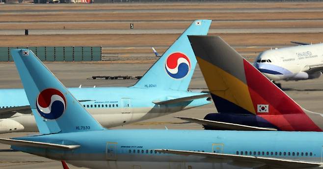 12일 영종도 인천국제공항 주기장에 합병을 앞둔 대한항공과 아시아나항공의 항공기가 보인다. 연합뉴스