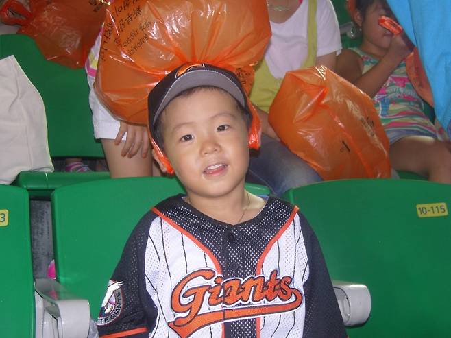 ▲ 5살이던 2008년 사직구장에서 주황색 비닐봉지를 쓰고 롯데를 응원하고 있는 한태양. 부산에서 태어난 한태양은 자주 사직구장을 찾으며 야구선수의 꿈을 키웠다. ⓒ한태양 제공