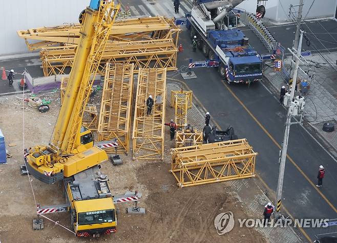 한곳에 모인 크레인 부품들 (광주=연합뉴스) 김도훈 기자 = 광주 서구 신축아파트 붕괴사고 발생 엿새째인 16일 관계자들이 타워크레인 해체 작업에 투입될 크레인 조립 준비 작업을 하고 있다. 2022.1.16 superdoo82@yna.co.kr