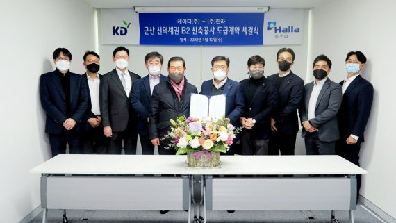 안태일 KD㈜ 회장(왼쪽 다섯번째)와 김선준 한라 개발사업본부장(왼쪽 여섯번째)가 지난 12일 군산 신역세권 B2 신축공사 동급계약을 체결한 뒤 기념촬영을 하고 있다.