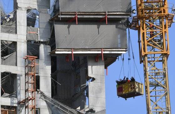 17일 오전 광주광역시 서구 화정동 현대산업개발 신푹 아파트 붕괴사고 현장에서 소방당국 등 관계자들이 크레인을 타고 사고 현장을 점검하고 있다. 프리랜서 장정필