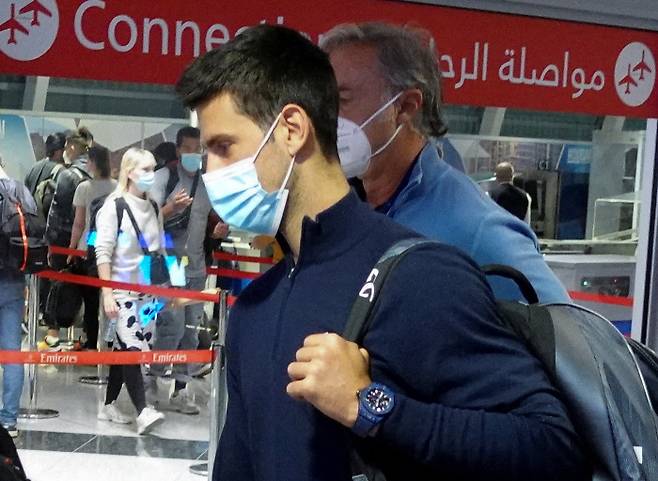 코로나19 백신 미접종으로 호주오픈 출전이 무산된 노바크 조코비치가 17일 호주를 떠나 아랍에미리트연합 두바이 공항에 도착해 이동하고 있다.  두바이 | 로이터연합뉴스