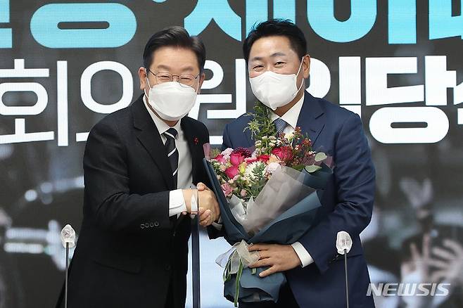 [서울=뉴시스] 국회사진기자단 = 이재명(왼쪽) 더불어민주당 대선 후보가 10일 오전 서울 여의도 당사에서 열린 김관영·채이배 전 국회의원 입당식에 참석해 김관영 전 바른미래당 의원에게 꽃다발을 전달하고 있다. 2021.12.10. photo@newsis.com