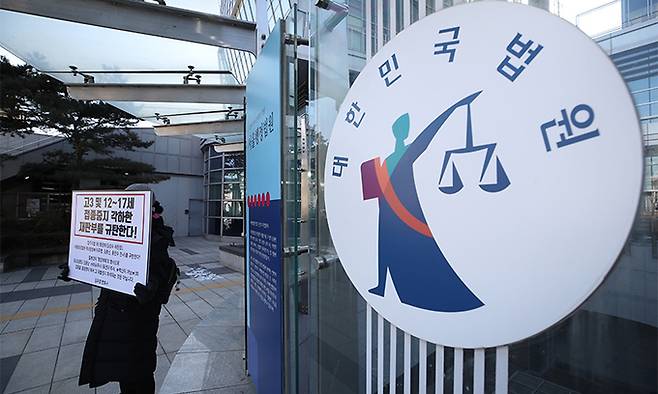 지난 14일 서울 서초구 서울행정법원 앞에서 한 학부모가 고3 및 12~17세의 코로나19 백신 접종 중지를 각하한 재판부를 규탄하는 피켓을 들고 1인 시위하고 있다. 뉴시스