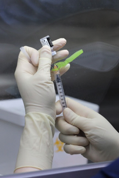 코로나19 환자 치료 의료진을 대상으로 한 화이자 백신 접종이 시작된 서울시 중구 국립중앙읭료원 중앙예방접종센터 내 무균 작업대(클린벤치)에서 의료진이 화이자 백신을 주사기에 소분 조제하고 있다. |사진공동취재단