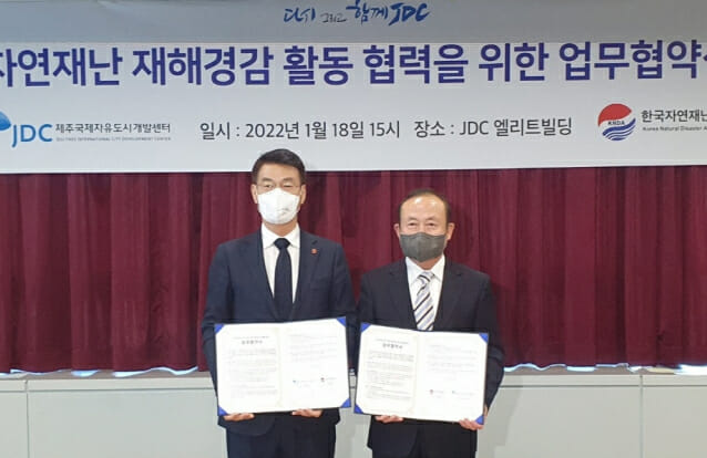 문대림 JDC 이사장(왼쪽)과 전병성 한국자연재난협회 회장이 18일 JDC 회의실에서 협약을 체결한 후 협약서를 들어보이고 있다.