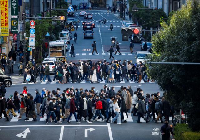 신종 코로나바이러스 감염증(코로나19) 오미크론 변이가 급속도로 확산되는 도쿄에서 지난 15일 마스크를 쓴 시민들이 횡단보도를 건너가고 있다. 도쿄=로이터 연합뉴스