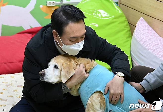 윤석열 국민의힘 대선 후보가 19일 오후 경기도 용인시 처인구 삼성화재 안내견학교를 방문해 장애인 관련 정책공약 발표에 앞서 은퇴한 안내견을 포옹하고 있다. 2022.1.19/뉴스1 © News1 국회사진취재단