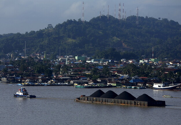 인도네시아 보르네오섬 이스트칼리만탄의 도시 사마린다. 견인선 한 척이 석탄을 실은 바지선을 끌고 있다. 2016년 3월2일 촬영했다. 로이터 연합뉴스 자료사진