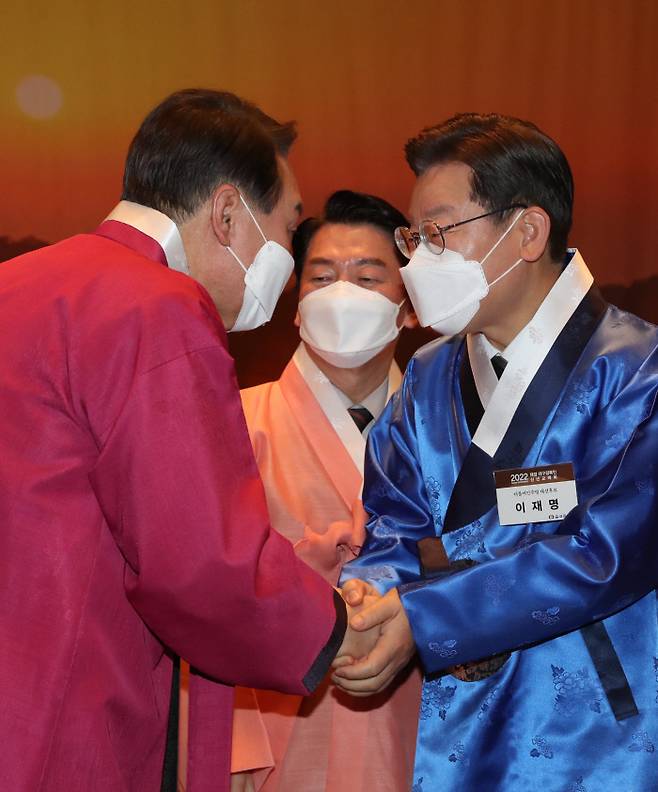 이재명 더불어민주당 대선 후보(오른쪽)와 윤석열 국민의힘 대선후보가 17일 서울 중구 프레스센터에서 열린 재경 대구경북인 신년교례회에 참석해 악수하고 있다. 가운데 국민의당 안철수 대선후보. 국회사진기자단