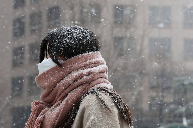 A woman walks pass by Cheonggye Plaza in central Seoul on Wednesday morning, when a heavy snow advisory was issued for the entire area of ​​Seoul. (Yonhap)
