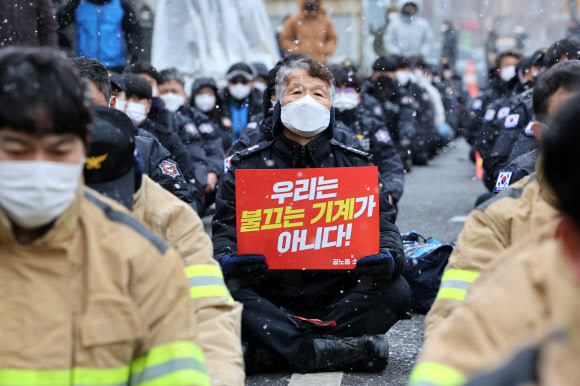 소방공무원노조 소속 소방관들이 지난 17일 청와대 앞에서 “우리는 불끄는 기계가 아니다”라며 현장 지휘체계 개편 등을 요구하고 있다. 연합뉴스