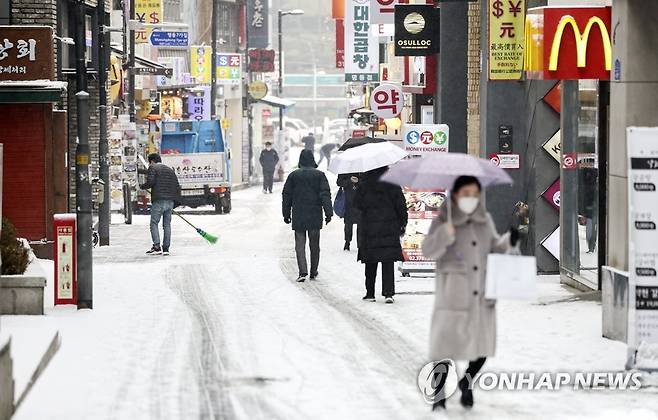 눈 오는 명동거리 (서울=연합뉴스) 윤동진 기자 = 수도권 대설주의보가 발효된 19일 오전 서울 명동에서 시민들이 길을 걷고 있다. 2022.1.19 mon@yna.co.kr