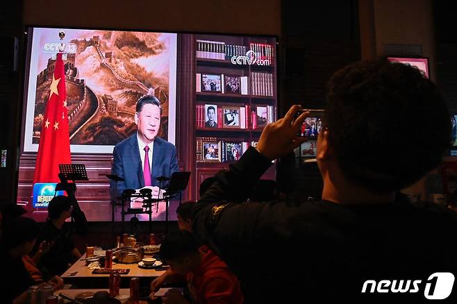 31일(현지시간) 시진핑 중국 국가주석의 신년 연설 모습을 베이징의 레스토랑 손님이 사진을 찍고 있다. © AFP=뉴스1 © News1 우동명 기자
