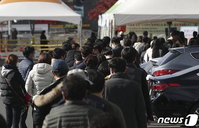 신종 코로나바이러스 감염증(코로나19) 일일 신규 확진자 수가 처음으로 7000명을 넘어선 8일 울산 중구 종합운동장에 마련된 임시 선별검사소에서 시민들이 검사를 받기 위해 줄지어 서 있다. 2021.12.8/뉴스1 © News1 윤일지 기자