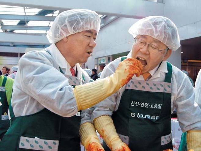 2012년 11월 당시 최윤길(왼쪽) 성남시의회 의장이 성남시 농수산물유통센터에서 열린 김장 행사에서 이재명 당시 성남시장에게 김치를 먹여주고 있다. /독자 제공