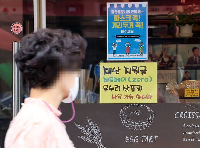 재난지원금 지급 방식을 둘러싸고 '선별지급'이냐 '전국민 지급'이냐 논란이 끊이지 않는다. 지난해 5차 재난지원금 때는 하위 88% 국민에 1인당 25만원씩 지급하는 것으로 결정됐다. 지난해 9월 6일 서울 용산구 전통시장의 한 가게에 재난지원금 사용 가능 안내 문구가 붙어있다. /연합뉴스