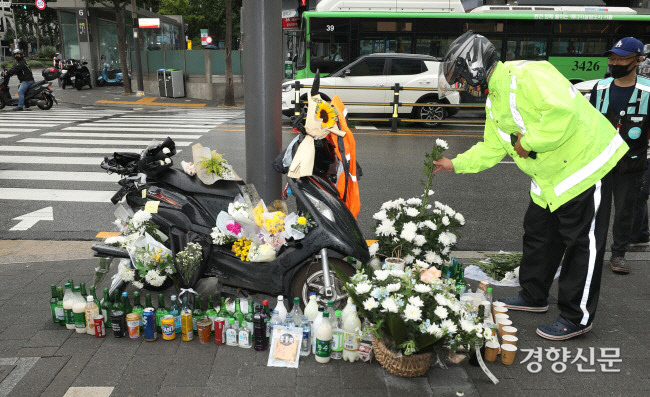 지난해 8월27일 서울 강남구 선릉역 앞에 화물차에 치여 숨진 오토바이 배달 노동자를 추모하며 꽃과 술이 높여있다. 강윤중 기자