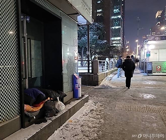 19일 저녁 서울 종로구 종각역 인근에서 한 노숙인이 침낭과 패딩 점퍼를 펴 놓고 잠을 청하고 있다. / 사진 = 오진영 기자