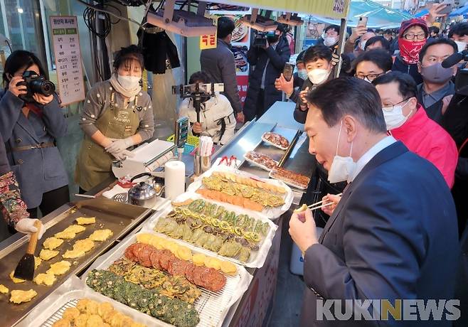 윤석열 국민의힘 대선후보가 21일 오후 대전 동구 중앙시장의 한 전집을 방문해 전을 먹고 있다.   사진=조현지 기자