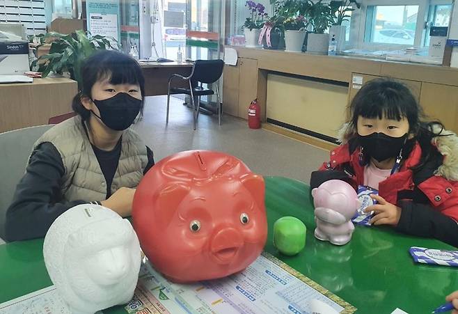 돼지 저금통 내민 자매. 운남면 제공