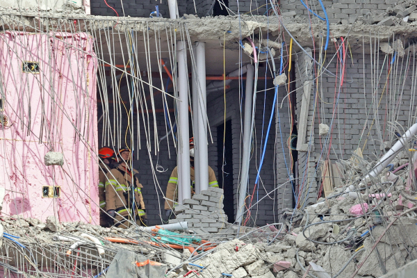 23일 오후 광주 서구 화정아이파크 붕괴사고 현장에서 119 구조대원들이 처참하게 부서진 건물 잔해 틈을 수색하고 있다. [사진 출처 = 연합뉴스]
