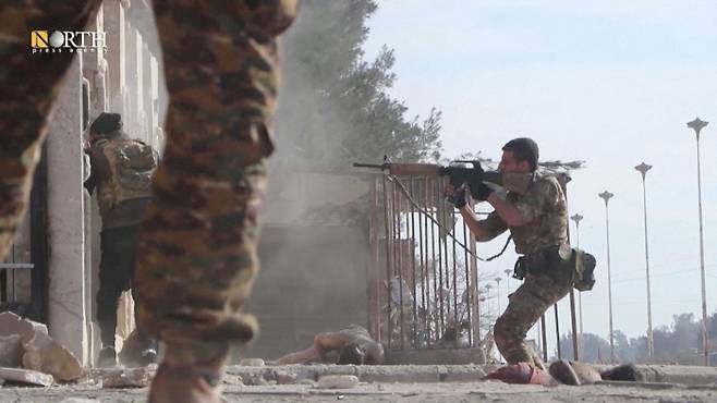 시리아 쿠르드족 민병대 시리아민주군(SDF) 소속 대원들이 22일(현지시간) 북동부 하사카 과이란 이슬람국가(IS) 포로 수용소 외곽에서 탈옥을 시도하는 IS 포로들과 총격전을 벌이고 있다. 하사카|로이터연합뉴스