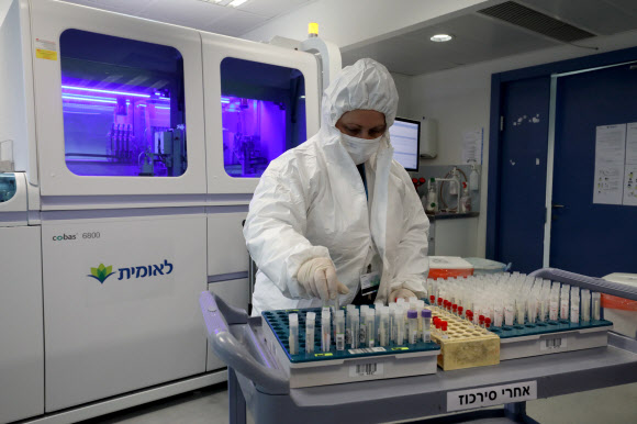 지난 22일(현지시간) 이스라엘 텔아비브 인근 오르예후다의 한 의학연구소에서 연구원이 코로나19 의심 환자의 샘플을 검사하고 있다. 오르예후다 신화 연합뉴스